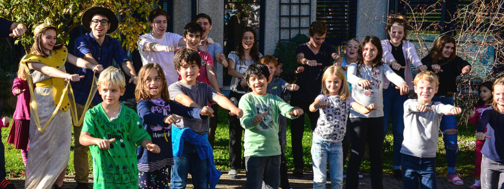 Teilnehmende singen und tanzen beim Altersheimbrunnen in einer, der bisherigen Kinderspielwochen